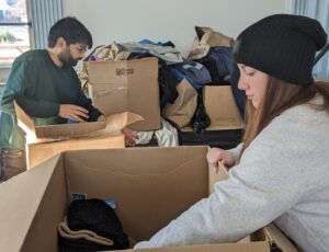 IIB volunteers assist with organizing hats, gloves, and jackets during our annual winter coat drive